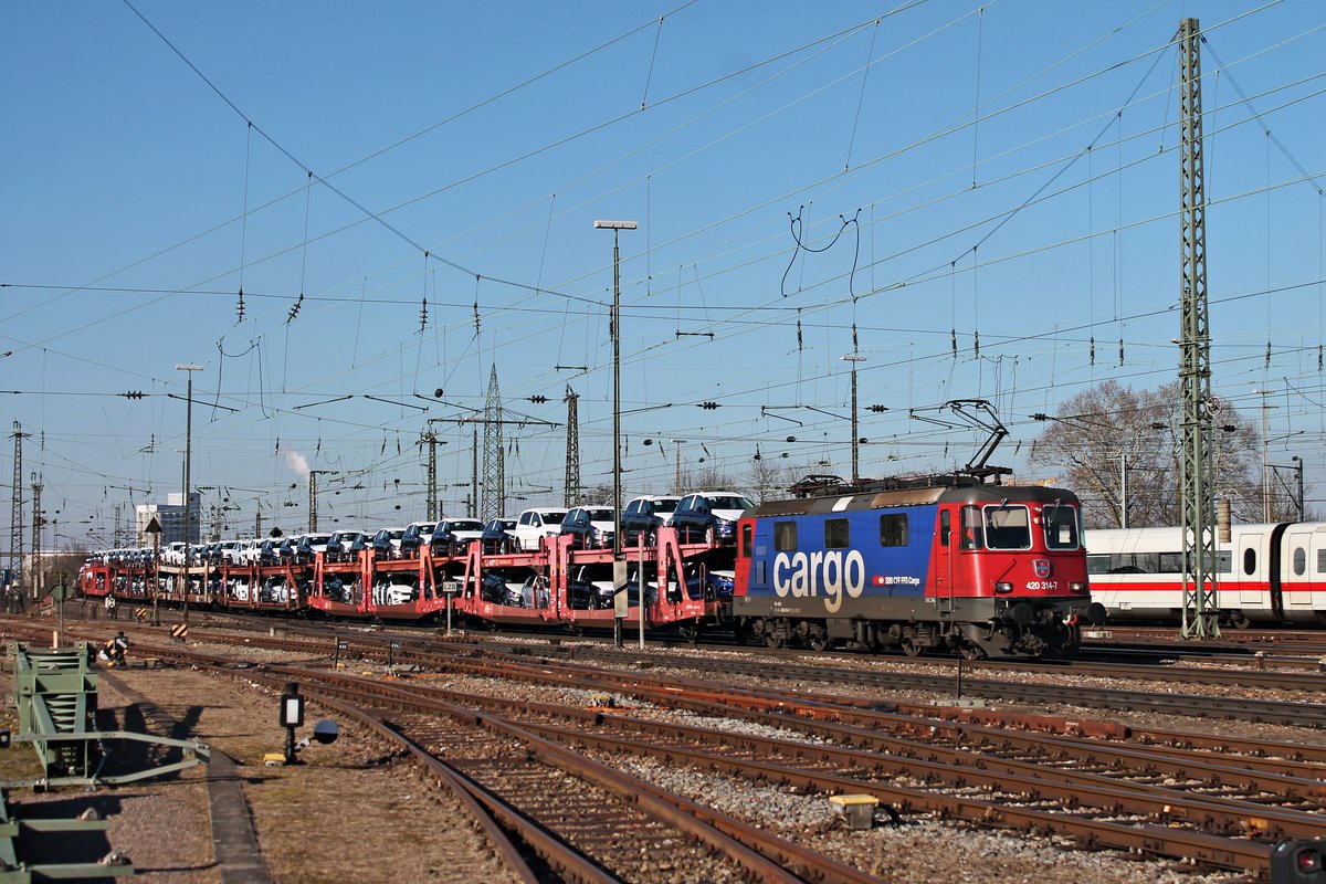 Durchfahrt am 14.02.2018 von Re 420 314-7 mit einem langen VW-Autozug durchs nördliche Vorfeld vom Badischen Bahnhof von Basel in Richtung Rangierbahnhof Muttenz.
