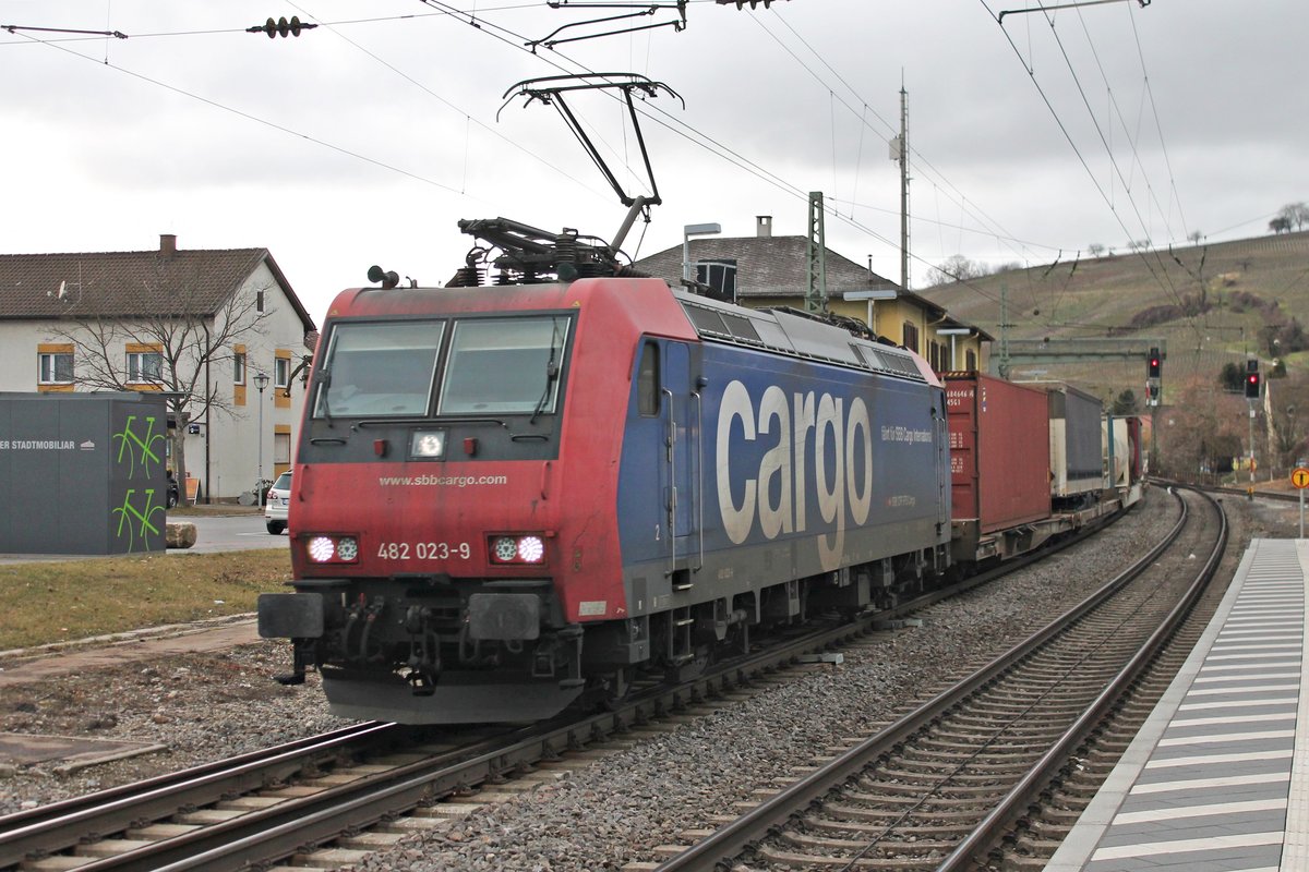 Durchfahrt am 21.02.2017 von Re 482 023-9  fährt für SBB Cargo International  mit ihrem bunten Containerzug durch den Bahnhof von Efringen-Kirchen in Richtung Schweizer Grenze.