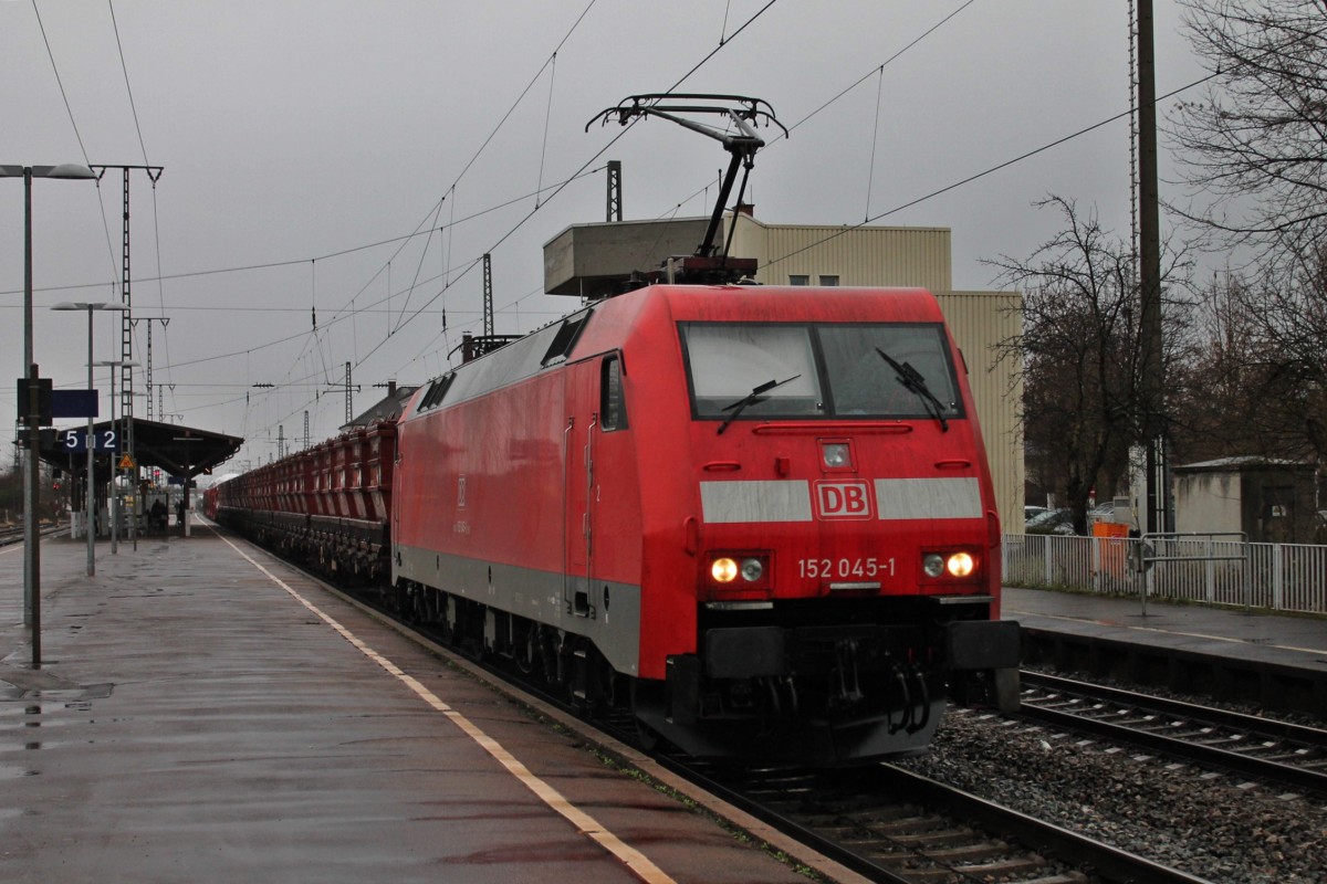 Durchfahrt am 28.02.2014 von der 152 045-1 bei strömenden Regen mit einem langen gemischten Güterzug in Müllheim (Baden) gen Süden.