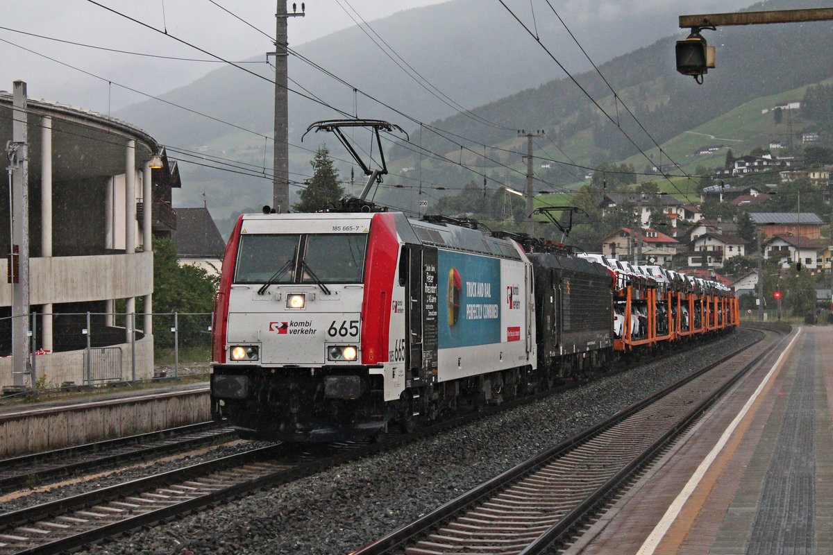 Durchfahrt am Mittag des 03.07.2018 bei einem Regenschauer von 185 665-7  TRUCK AN RAIL - kombiverkehr  zusammen mit MRCE/LM ES 64 F4-027 (189 927-7) und einem vollen Autotransportzug durch den Bahnhof von Matrei am Brenner in Richtung Italien.