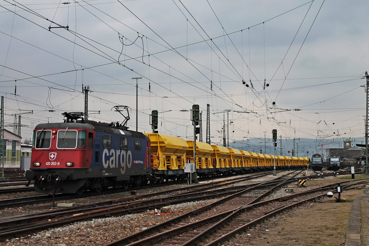 Durchfahrt am Nachmittag des 20.03.2018 von Re 420 262-8 mit einem leeren Schotterzug über Gleis 1 durch den Badischen Bahnhof von Basel in Richtung Basel Bad Rbf, wo der Zug dann von der SVG übernommen wird.