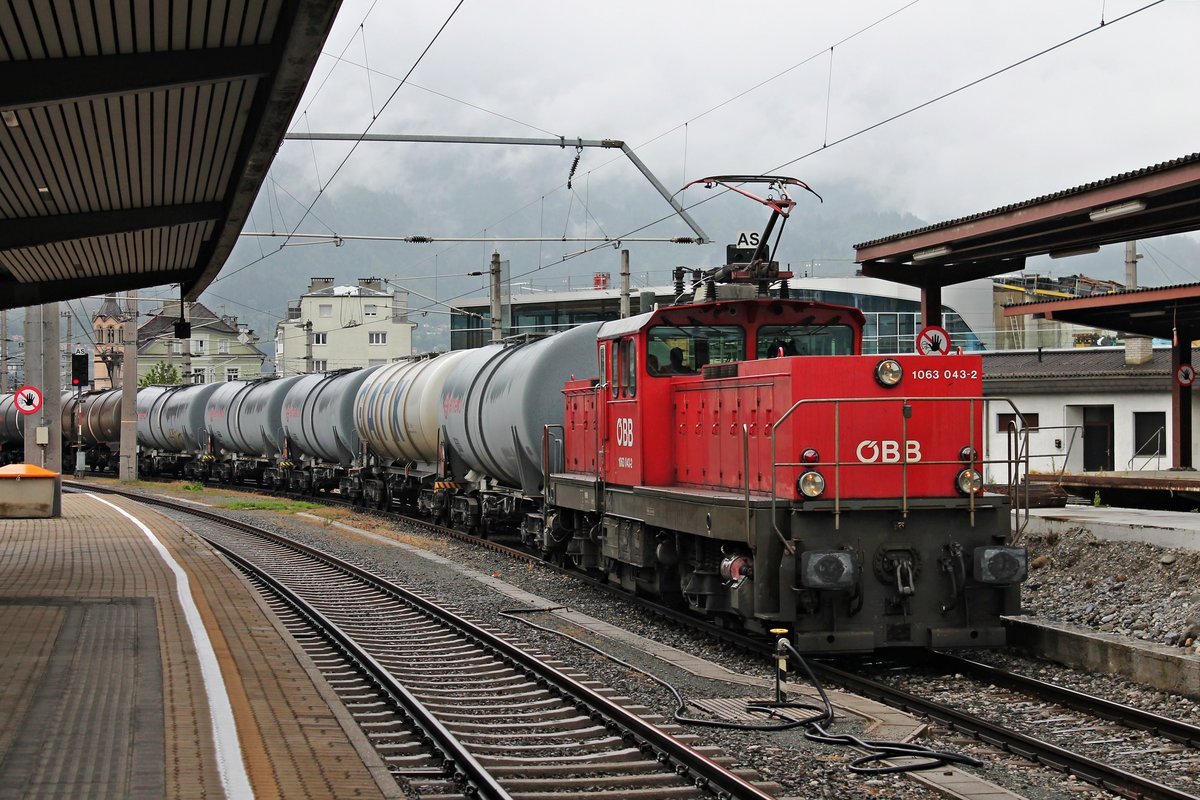 Durchfahrt am Vormittag des 06.07.2018 von der 1063 043-2 mit einem langen Kesselzug durch den Hauptbahnhof von Innsbruck in Richtung Süden.