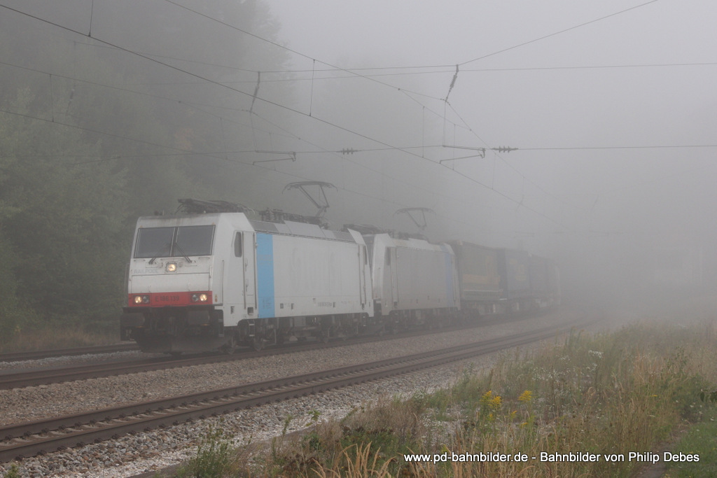 E 186 139 (Lokomotion) fhrt am 21. August 2013 um 8:26 Uhr zusammen mit 186 288-7 und einem Gterzug durch den dichten Nebel in Aling