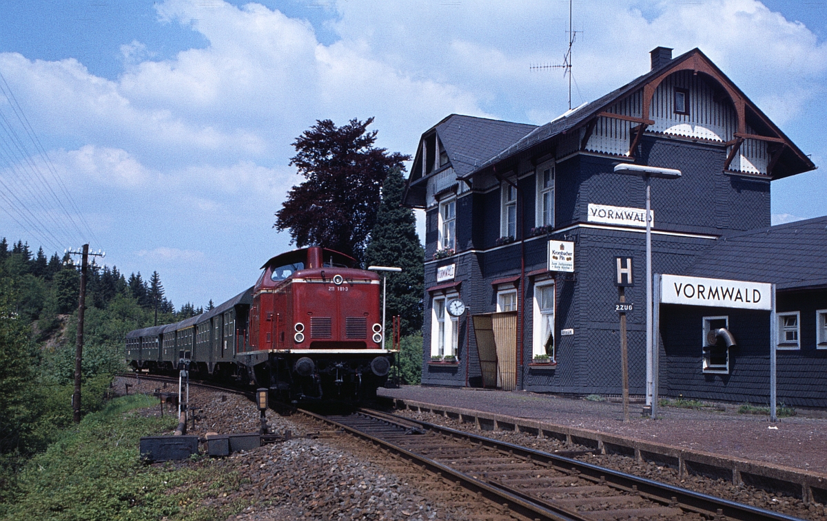 E 3593 Siegen-Erndtebrück-Marburg durchfährt den weitab von der namensgebenden Ortschaft gelegenen Bahnhof Vormwald. Ortnähner gibt es weiter unten im Tal den Hp. Vormwald Dorf. 211 181 war damals in Kassel beheimatet (April 1978).