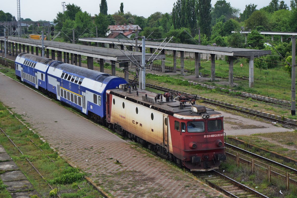E-Lok 91-53-0-40-0912-8 mit zweiteiliger Doppelstockwagengarnitur fährt am 13.05.2017 Bahnhof Roman nach Suceava ab.