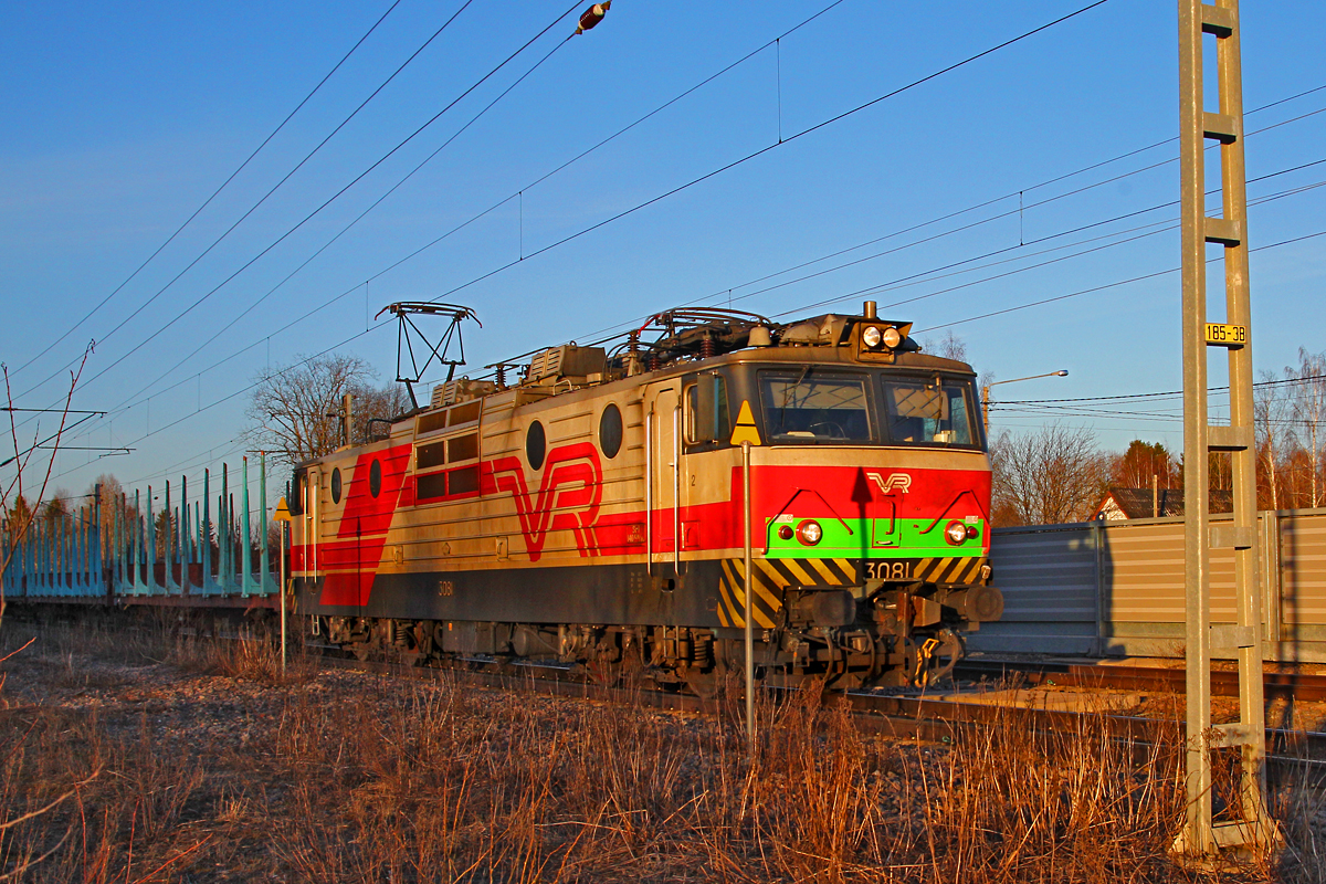 E-Lok SR1 3081 durchfährt den Bahnhof Koria mil leerem Holzzug.Das Foto entstand am 10.4.2014