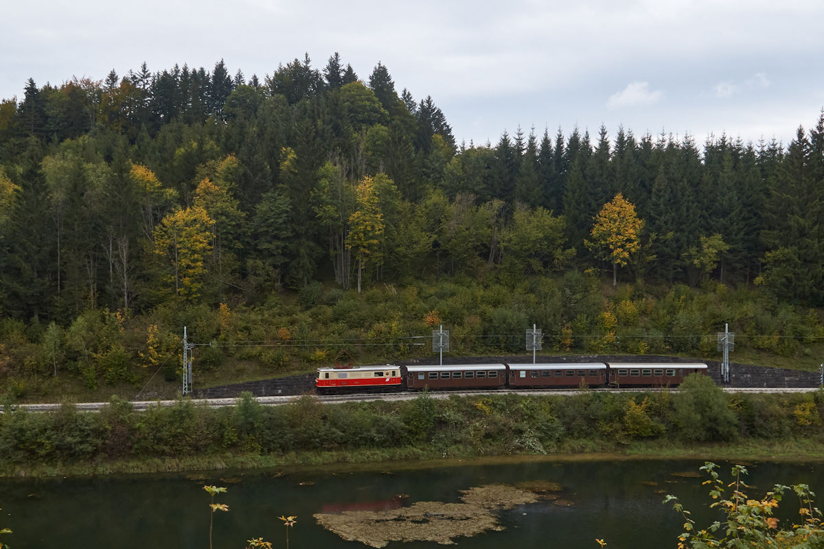 E14 der NVOG (als 1099.014 der BB) war am 29.09.2021 mit einem Personenzug in Richtung St. Plten unterwegs. Gerade hat der Zug Wienerbruck-Josefsberg verlassen und fhrt entlang des Ufers des Stausees. (Fotohalt)