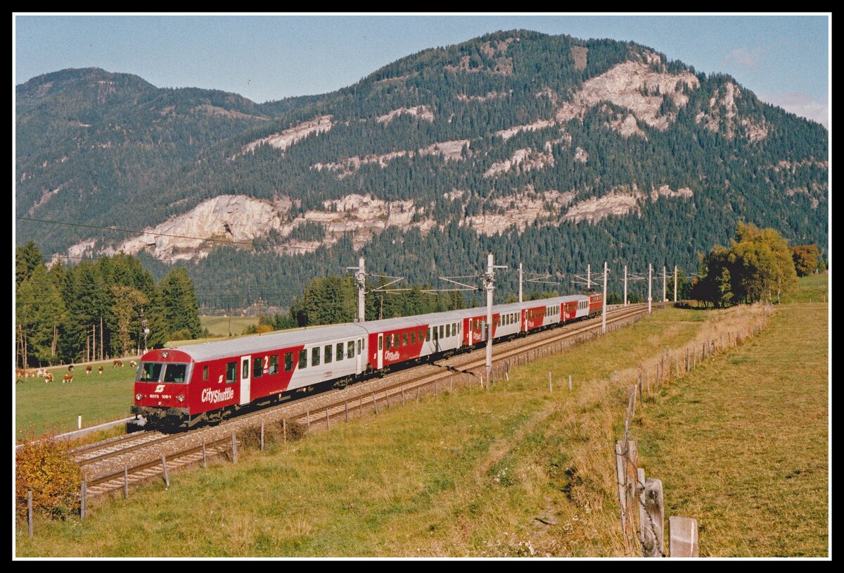 E1692 (Bruck/Mur - Villach) geführt von Steuerwagen 80-73 106 ereicht bald den Bahnhof Mariahof St.Lamprecht. Das Foto entstand am 8.10.2002. Im Hintergrund ist der Puxberg zu erkennen der durch seine Höhlenburgen, genannt auch  Puxer Loch  bekannt ist.