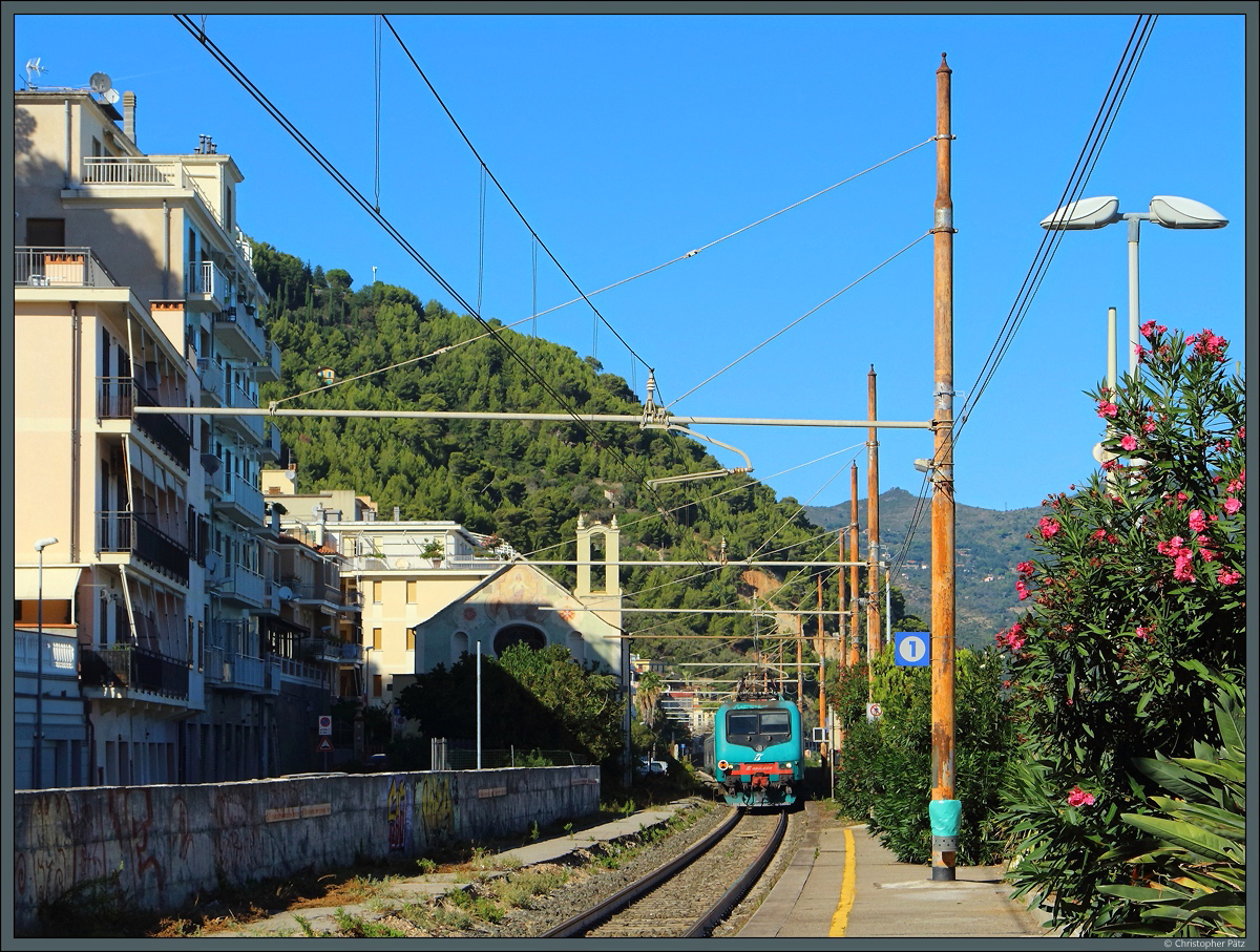E.464 398 erreicht am 25.09.2018 mit dem R 6182 nach Ventimiglia den ligurischen Küstenort Laigueglia und passiert dabei die kleine Kirche Chiesa dell'Immacolata Concezione. 