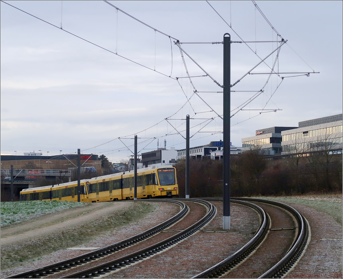 Ebenerdig -

... verläuft die Stadtbahnstrecke weiter in Richtung Flughafen. Nach einem sanften Hügel senkt sich der Stadtbahnzug wieder zur nächsten Talsohle ab.

Bei Echterdingen, 07.01.2022 (M)