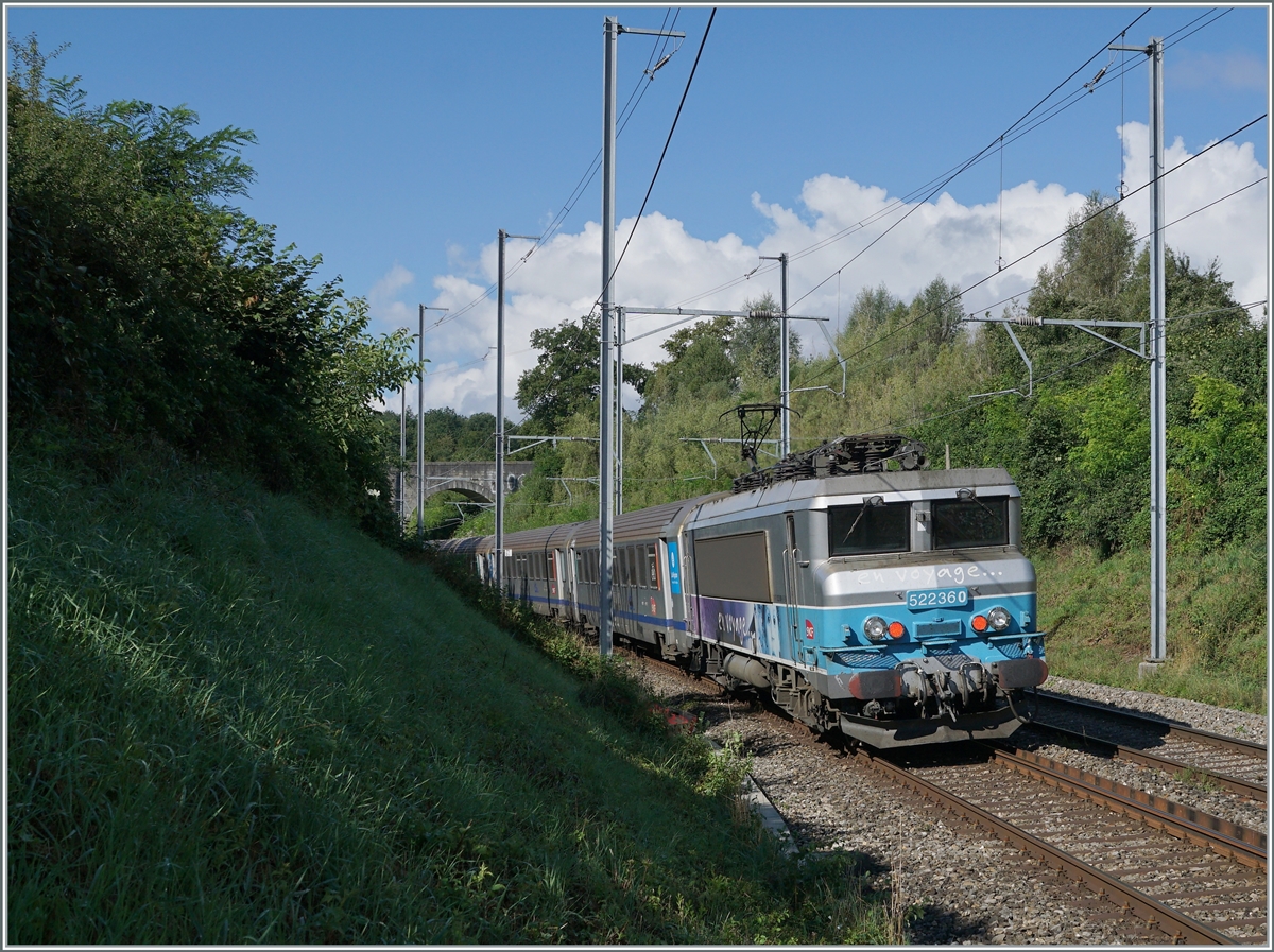 Ebenfalls kurz vor der Steinbogenbrücke, die sich auf dem halben Weg zwischen Satigny und Russin befindet und im Hintergrund erkennbar ist, schiebt die SNCF BB 22360  Nez cassé  ihren TER in Richtung Lyon.

2. August 2021