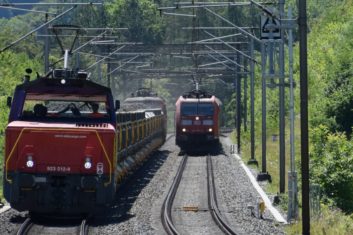 Eem 923 012-9 mit Re 4/4 III 11350 am Zugschluss (geschleppt) liefert sich bei Schinznach-Dorf am 12.07.2018 mit ihrem Aushubzug ein  Rennen  mit BR 185 099-9, welche ihrerseits ihren Güterzug auf dem regulären Gleis in Richtung Brugg zieht.