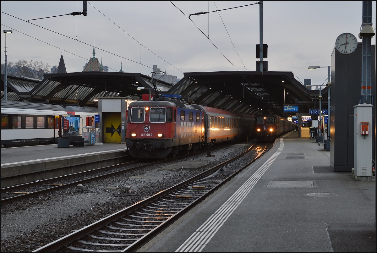 Eher in Skandinavien würde man um 9:32 diese dunkle Stimmung vermuten, wären da nicht Re 421 379-9 und Re 4/4<sup>II</sup> 11245. Erstere bringt den Nachtzug aus Österreich in die Abstellung. Zürich, Dezember 2015.