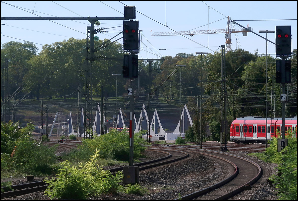 Eher unscheinbar - 

... wirken die Stahlsegel der neuen Neckarbrücke vom Bahnhof Stuttgart-Bad Cannstatt aus gesehen. Am anderen Ende der Brücke werden die Bahnen den Rosensteinpark (im Hintergrund) in Tunnelröhren unterfahren. 

11.09.2018 (M)
