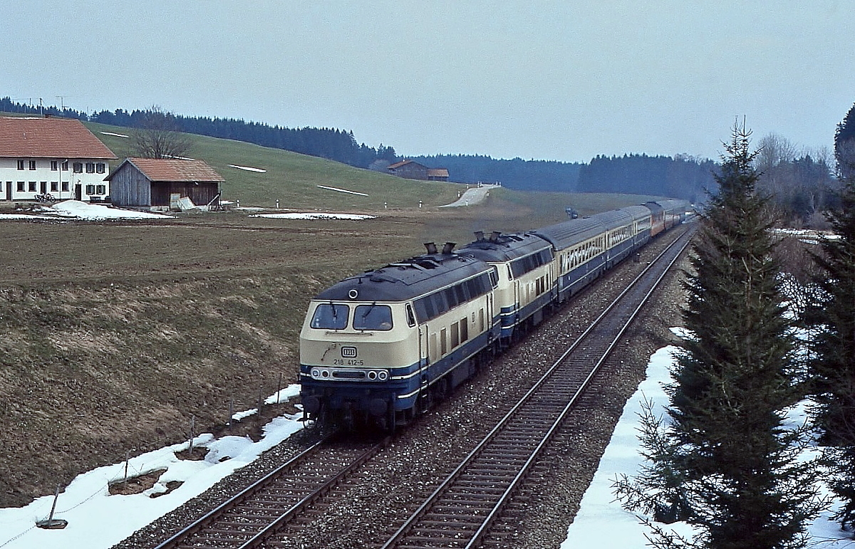 Ein 218-Doppel mit 218 412-5 an der Spitze fährt Anfang April 1989 auf der Allgäubahn bei Martinszell Richtung Süden