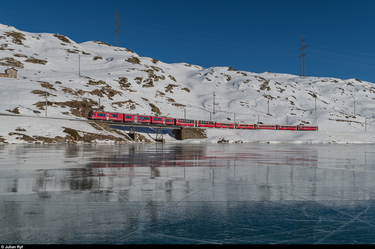 Ein Allegra fährt am 29. Dezember 2016 mit dem Regio 1644 Tirano - St. Moritz dem mit Schwarzeis bedeckten Lago Bianco entlang.