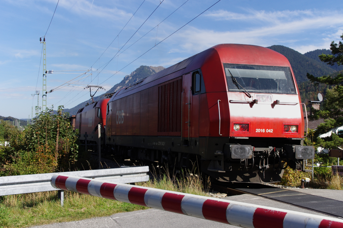 Ein außergewöhnlicher Zug.......ist der werktägliche Güterzug von Vils/Tirol nach Hall in Tirol. Da es für die Bahn über den Fernpass etwas schwierig wäre, muss der Zug außen herum, durch das Außerfern und über Mittenwald und den Seefelder Sattel.
Da zwischen Reutte und Vils kein Fahrdraht liegt, ist immer eine Diesellok mit am Zug, die die Anschlüsse bedient. Dann geht es gemeinsam, meist mit einem Eurorunner (Hercules) und einem Taurus auf die Strecke. Reutte - Garmisch-Partenkirchen (Außerfernbahn) - GP - Mittenwald - Innsbruck (Mittenwaldbahn) und Innsbruck - Hall in Tirol (Unterinntalbahn), so ist der interessante Laufweg des Zuges. ÖBB Hercules 2016 042 und ein Taurus haben mit ihren Güterzug gerade den Bahnhof Mittenwald durchfahren und die Isar überquert. Gleich wird die Grenze Deutschland - Österreich erreicht und bei Scharnitz beginnt der Aufstieg zum Seefelder Sattel. Bahnstrecke 5504 am 10.10.2014