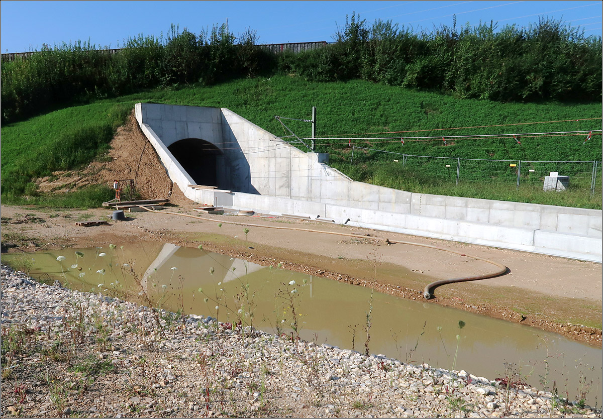 Ein Bahntunnel unter der Autobahn -

Für die Güterzuganbindung bei Wendlingen-Unterbohingen musste die Autobahn A8 in einem 175 m langen Tunnel unterfahren werden. Dieser wurde vermutlich bergmännisch gebaut. Jenseits der Autobahn führt das Gleis in einem Trog weiter um dann erst im Albvorlandtunnel höhengleich in die Neubaustrecke einzumünden. 

14.08.2021 (M)