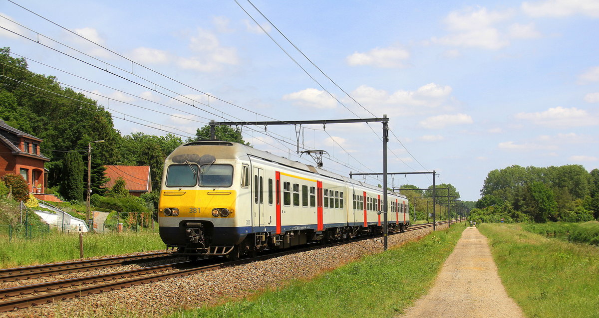Ein Belgischer Triebzug 381 von der SNCB und fährt durch Testelt(B) in Richtung Aarschot(B).
Aufgenommen von der Wijngaardstraat in Testelt(B).
Bei Sommerwetter am 1.6.2019. 