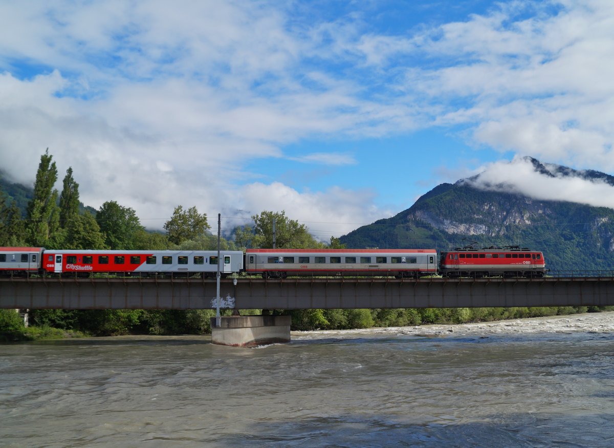 Ein besonderer Tag für die Eisenbahn in Tirol war der 11. Juni 2020. An besagtem Fronleichnamstag kam nämlich eine 1142 der ÖBB nach Tirol, was planmäßig seit mehr als 10 Jahren Geschichte ist. Möglich machte dies das Zugpaar IC 515/518, das gerne mit Loks des Stützpunktes Graz bespannt wird. Nachdem sie am Vortag den 518 nach Innsbruck gebracht hatte, zog die sogar noch mit großen Scheinwerfern ausgestattete 1142 684 am Morgen des 11.6. den IC 515  Hahnenkamm  (Innsbruck Hbf - Graz Hbf), der des Feiertages wegen mit einigen CS-Wagen verstärkt war, in Richtung Osten. Bei sich auflösender Restbewölkung konnte die historisch wertvolle Leistung bei der Überquerung des stürmischen Inns in Brixlegg fotografiert werden. 