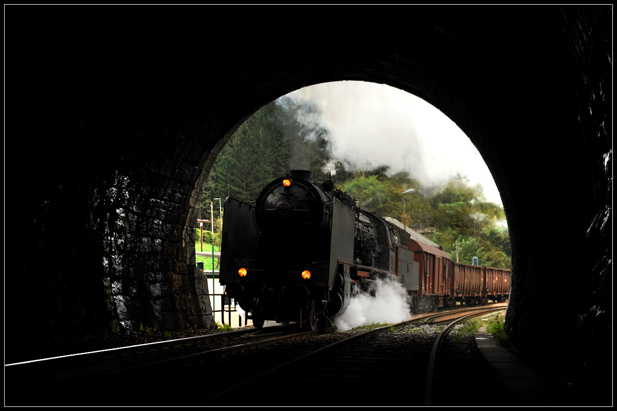 Ein Bild, bei dem sich jetzt bei der Freischaltung sicher die Geister scheiden werden. Auch dieses, ziemlich berühmte Fotomotiv, erfolgte natürlich mit Abstimmung Bahnhofs- und Lokpersonal. Hinter mir endet übrigens das Gleis, auf dem ich stehe.  Zur Erklärung: Aus Kostengründen wurde nur der Wocheiner Tunnel der Wocheiner Bahn zweigleisig ausgeführt, musste aber wegen Wassereinbruch eingleisig rückgebaut werden, wobei auf der Nordseite das ehemalige zweite Gleis heute als Bach dient. Bei starken Regenfällen und/oder bei der Schneeschmelze wird aber auch das aktive Gleis überschwemmt. Bis 20 Zentimeter Wasser über Schienenoberkante wird ganz normal auch mit den dieselelektrischen Maschinen durch den Tunnel gefahren. Über 20 Zentimeter wird dies mit den  dieselelektrischen Maschinen allerdings zu gefährlich und es verkehren bis 40 Zentimeter Wasser über Schienenoberkante nur mehr Triebwagen. Ab 40 Zentimeter Wasser über der Schienenoberkante wird der Betrieb dann eingestellt. 

Das Bild zeigt übrigens 06-018 mit ihrem 17032 von Nova Gorica nach Jesenice am 10.10.2015 bei der Einfahrt in den 6.327,4 Meter langen Bohinj-(Wocheiner-)Tunnel.
