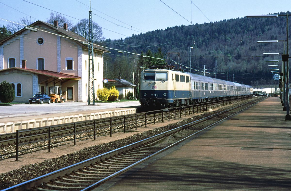 Ein Bild des Bahnhofs Pappenheim von 1996 - die DBAG ist erst gut zwei Jahre alt. Lok 111 001 fährt mit einem RE München - Nürnberg in den Bahnhof Pappenheim ein. Die Baureihe 111 ist hier seit Ende der 1970er Jahre unterwegs, ab der Eröffnung der Neubaustrecke Ingolstadt - Nürnberg bis zum April 2018 waren sämtliche Reisezüge mit Lok 111 bespannt.
Pappenheim, 21. April 1996