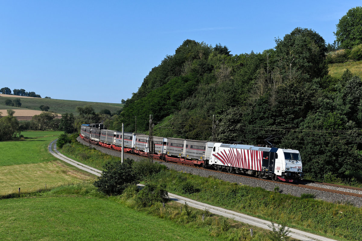 Ein Bild einer Lokomotion-Leistung im Haunetal war mir bisher nicht vergönnt. Das änderte sich am 19. Juli 2020, als mir das  Teufelszebra  185 666 mit dem DGS 43822 von Verona Q.E. nach Bremen Grolland bei Hermannspiegel vor die Linse fuhr. Hinter der Lok war der KLV-Zug einheitlich mit Wechselbrücken und Aufliegern der Spedition Terratrans beladen.  