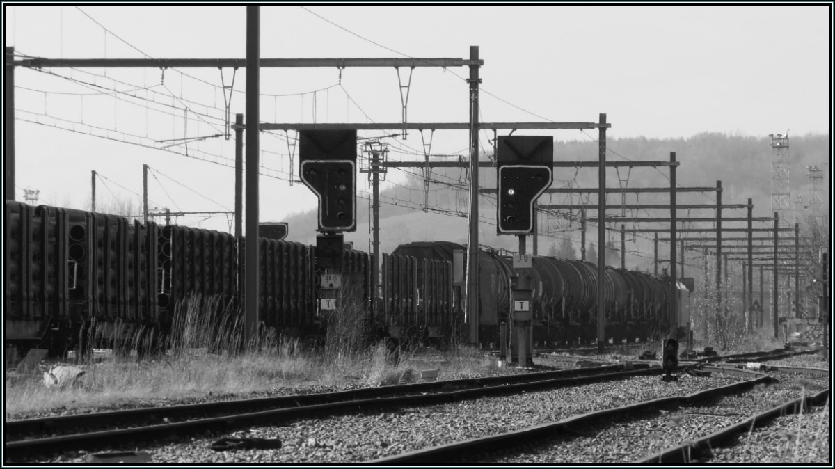 Ein Blick hinein auf den Güterbahnhof in Montzen (Belgien).Ein gemischter Güterzug ist gerade unterwegs in Richtung Antwerpen.Schwarzweiß Szenario vom März 2014.