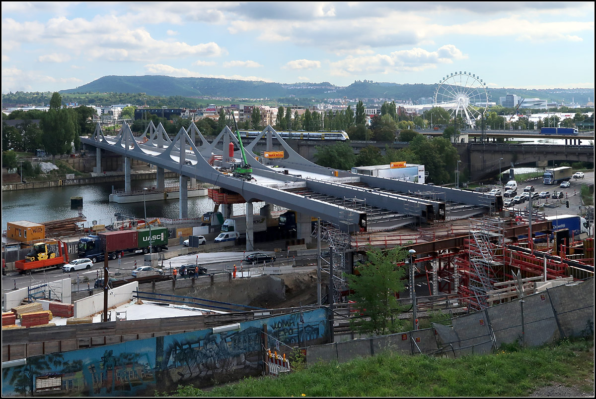 Ein Blick von oberhalb -

... auf die neue Bahnbrücke in Stuttgart-Bad Cannstatt. Dahinter ist auf der alten Brücke ein Talent 2-Zug unterwegs. Mit dem Riesenrad wirft das Cannstatter Volksfest seien Schatten voraus. Weiter rechts ist das Mercedes-Benz-Museum zu erkennen.

13.09.2019 (M)