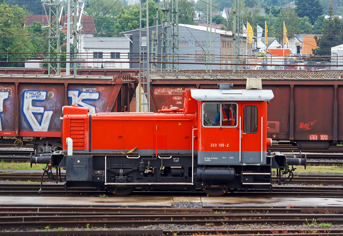 Ein Blick über den Zaun am Bahnbetriebshof Limburg/Lahn....

Die Köf III – 333 135-2 der DB Regio AG rangiert am 26.05.2014 in Limburg/Lahn.
Die Köf III wurde 1974 bei Jung, Jungenthal bei Kirchen an der Sieg unter der Fabriknummer 14189 gebaut und an die DB - Deutsche Bundesbahn geliefert. Eigentlich wurde sie 2004 z-gestellt und 2005 ausgemustert und wurde bei der DB Regio, Betriebshof Frankfurt (Main)-Griesheim als Gerät im internen Verschub verwendet.
Daher freut es mich das sie nun immer noch Verwendung findet.

Die Köf III (Kleinlok mit Öl-(Diesel-)Motor und Flüssigkeitsgetriebe, Leistungsgruppe III) der Baureihe 333 haben einen Motor MWM (Motorenwerke Mannheim) RHS 518A mit einer Nennleistung von 177 kW (240 PS) bei 1.600 U/min dessen Leistung über ein hydraulische Wendegetriebe L213U von Voith, von diesem über Gelenkwellen auf die zusätzlich vorhandenen Achsgetriebe (nicht wie ältere Ausführung der BR 331 über Rollenketten).

Weitere Technische Daten:
Achsformel : B
Länge über Puffer: 7.830 mm
Dienstmasse (2/3 Vorräte): 22 t
Dieselkraftstoff: 300 l
Höchstgeschwindigkeit: 45 km/h
Anfahrzugkraft: 83,4 kN