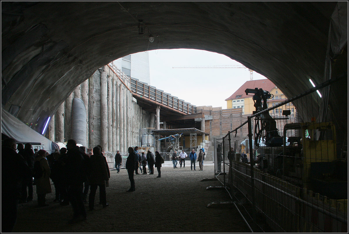 Ein Blick zurück in den Startschacht -

Der Tunnel bis zum Bahnhof mit der Weichenstraße wird in offener Bauweise gebaut. Das rechts oben erkennbare ehemalige Bahndirektionsgebäude wird dabei aufwändig unterfahren. Der dem Bahntunnel im Weg liegende Stadtbahntunnel wird momentan in tieferer Lage in NÖT neu gebaut.

Tage der offenen Baustelle, 06.01.2016 (M)