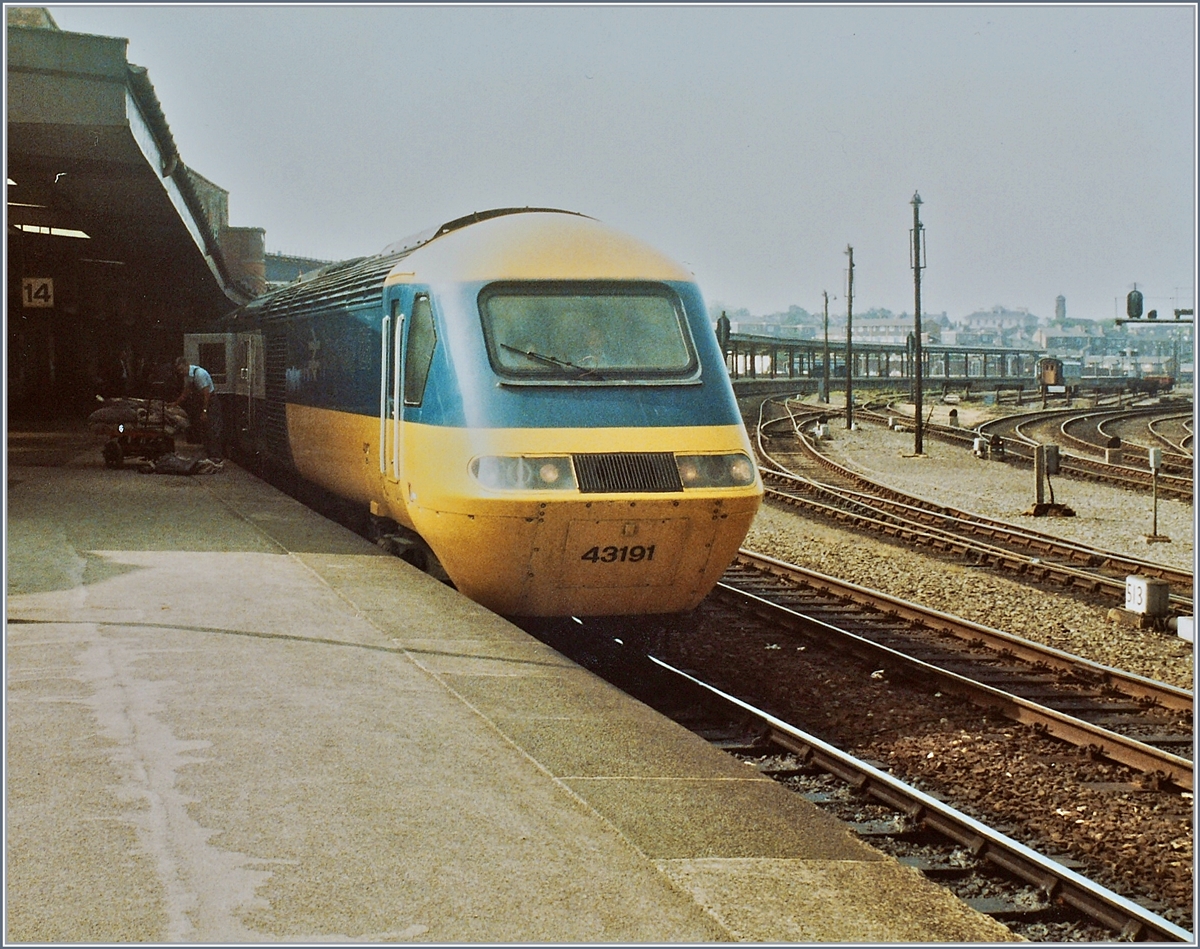 Ein British Rail HST 125 Class 43 steht in York am Bahnsteig und wartet auf die Weiterfahrt Richtung Norden.
Neben dem fotografisch nicht besonders gut platzierten  Triebkopf  43191 lohnt ein Blick auf die Gleisanlage rechts im Bild und auf ein Detail links im Bild: Obwohl etwas im Schatten, lässt sich erkennen, das beim Gepäcktabteil der  Triebkopf  Gegenstände aus- bzw. eingeladen werden. 
20. Juni 1984