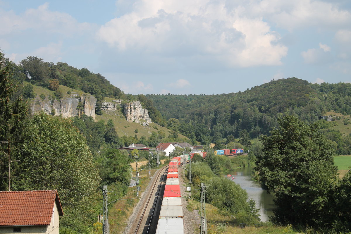 Ein bunter Containerzug hat soeben den Esslingerbergtunnel mit 633m der längste Bahntunnel im Altmühltal verlassen. Als Zuglok fungiert 482 043-7 der SBB Cargo. Jetzt folgt der Zug immer der Altmühl, bis irgendwann Ingolstadt erreicht ist.Links zu sehen das ehemalige Wärterhaus vor dem Tunnelportal. 