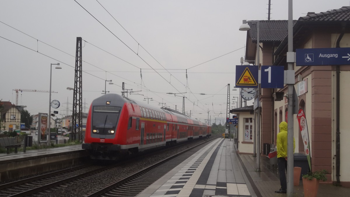 Ein DAbpbzfa 764 fhrt einen RE Heidelberg-Stuttgart an, hier gesehen bei Regenwetter in St. Ilgen/Sandhausen. Juli 2014.