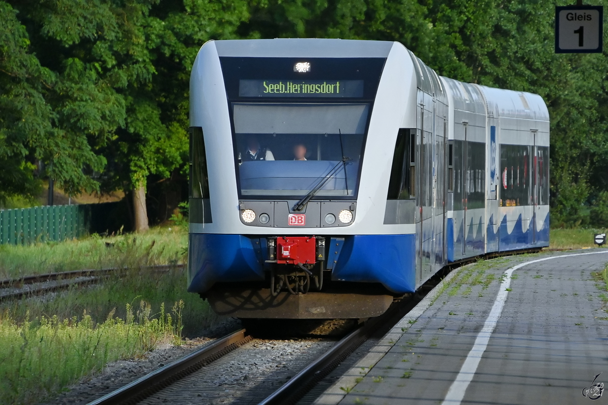 Ein Dieseltriebwagen der Usedomer Bäderbahn fährt gerade am Bahnhof Heringsdorf ein. (August 2021)