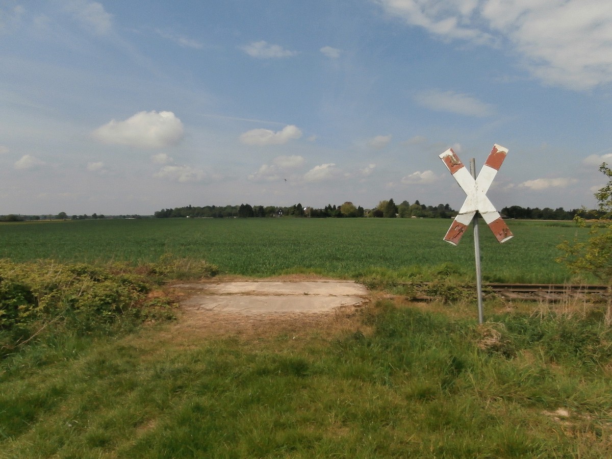 Ein ehemaliges Anschlussgleis, ein ehemaliger Bahnübergang und ein altes Andreaskreuz. Hier ist alles unbenutzt und wird sich selbst überlassen.  Mitte der 1950er Jahre wurden gleich zwei Anschlüsse für das NATO-Hauptquartier nordöstlich von Rheindahlen neu angelegt. Dies waren die Anschlußgleise Holt I(Bild) und Holt II der britischen Rheinarmee. Das Anschlußgleis Holt II verlief bis zum östlichen Ortsausgang Rheindahlens parallel zum Eisernen Rhein. Dort zweigte diese Anschlußbahn in nördlicher Richtung ab und endete auf einem Armeegelände kurz vor der Autobahn A 61 bei Genhülsen. Nahe Rheindahlen 26.04.2014