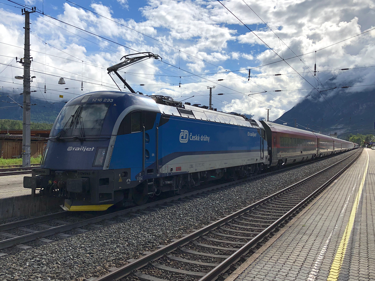 Ein fast 500 Meter langer Zug auf Bahnsteig 2 in Ötztal-Bahnhof mit Überraschungsgast ÖBB/ČD 1216 233-7 am Zugschluss des verkehrt gereihten RJX 862. Gleich dahinter war IC 119  Bodensee  nach Innsbruck Hbf geparkt. Aufgenommen am 30.06.2021