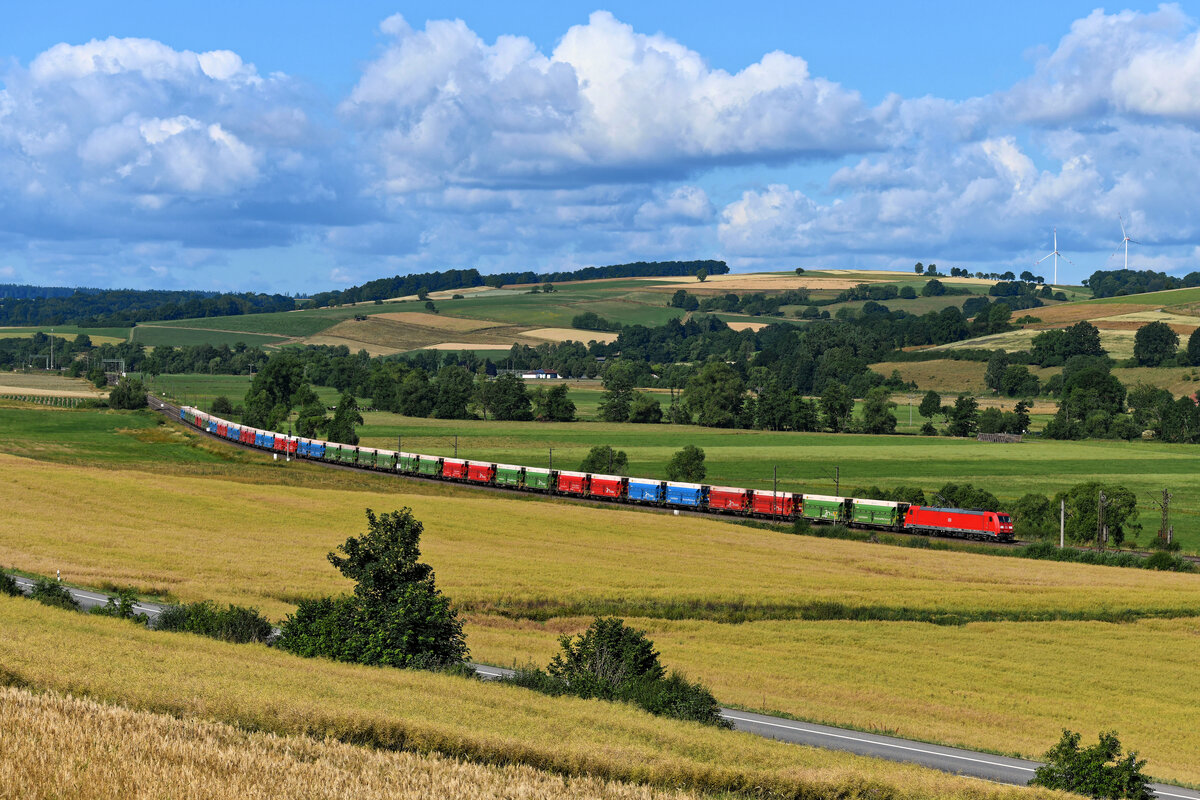 Ein Generationenwechsel fand beim Wagenmaterial der Erzzüge statt, die zwischen Norddeutschland und Österreich pendeln. Statt Waggons der Gattung Falns werden jetzt die RockTainer von Innofreight verwendet. Am 06. Juli 2023 begegnete mir ein solcher bunter Ganzzug bei Meisenbach im osthessischen Haunetal. Zuglok des GAG 47920 von Linz Stahlwerke nach Hamburg-Waltershof Hansaport war die 185 212 von DB Cargo. 
