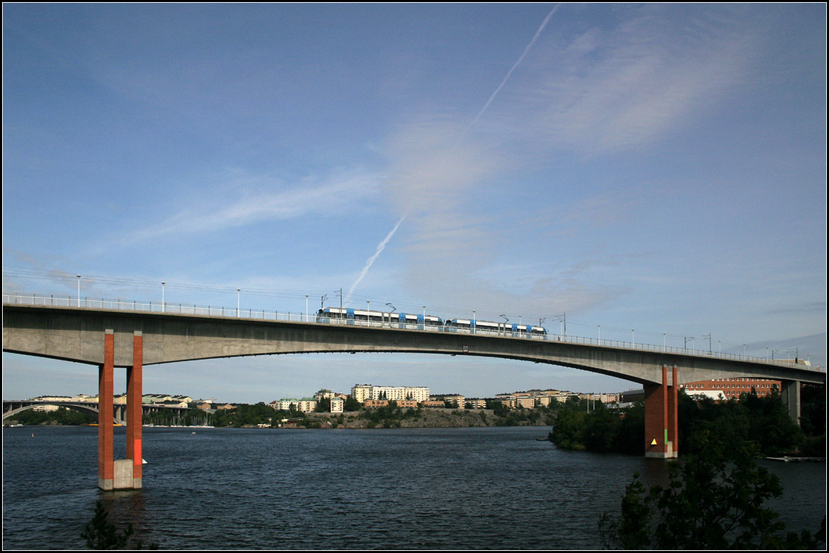 Ein große Brücke (mit Mängeln) für die Tvärbanan -

Tvärbanan, Alviksbron. Diese Brücke wurde eigens für die Stadtbahn gebaut. Sie verbindet den Stadtteil Alvik mit der Insel Stora Essingen. Wegen Rissebildung musste der Betrieb bald wieder eingestellt und die Brücke saniert werden. Neben der Bahn können auch Fußgänger und Radfahrer die Brücke überqueren.

Die Stochholmer Wasserflächen werden durch mehrere größer Brückenbauwerke überquert, wie die im Hintergrund links zu erkennende Tranebergbron, über die auch die T-Bana fährt.

21.08.2007 (M)