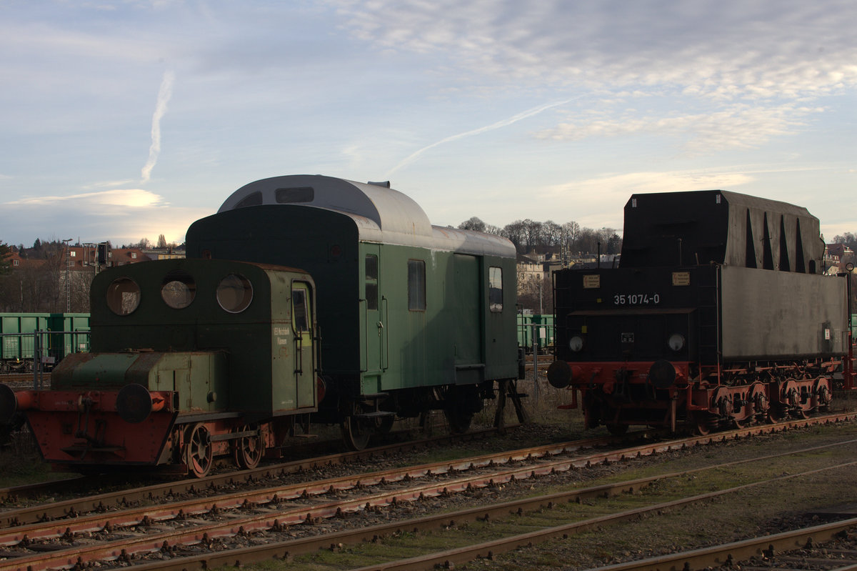 Ein Güterzuggepäckwagen flankiert von einer Kleinlok und einem Tender, der zur 35 1074-0 gehört. Gera, Eisenbahmwelten 10.12.2016 14:31 Uhr.Leider ist der Puffer der Kleinlok etwas abgeschnitten.