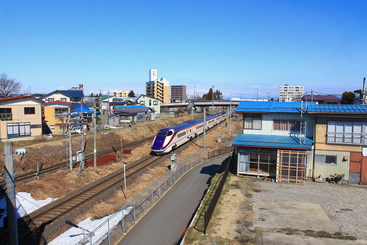 Ein Hochgeschwindigkeitszug des Yamagata Shinkansen (E3 Nr.1003) fährt aus dem Städtchen Yonezawa auf dem Yamagata Hochplateau aus, Richtung Tokyo. 18.März 2019 