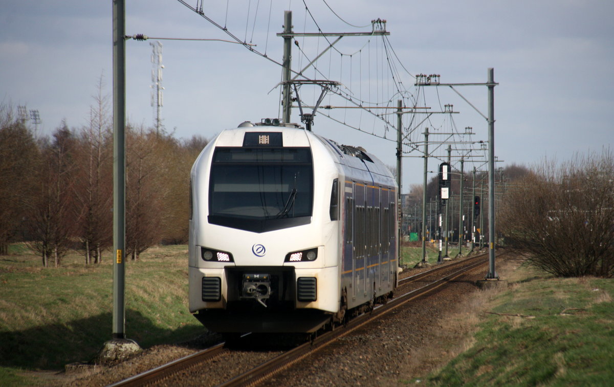 Ein Holländischer Regionalzug aus Roermond(NL) nach Maastricht-Randwyck(NL) und fährt in Geleen-Lutterade ein und hält in Geleen-Lutterade(NL) und fährt dann weiter in Richtung Maastricht(NL). Aufgenommen in Geleen-Lutterade(NL). Bei Sonnenschein und Wolken am Kalten Mittag vom 28.2.2017.