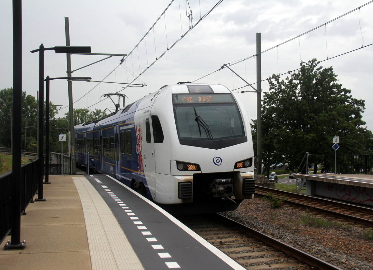 Ein Holländischer Regionalzug kommt aus Maastricht-Randwyck(NL) nach Heerlen(NL) und hält in Heerlen-Woonboulevard(NL) und fährt dann weiter in Richtung Heerlen(NL).
Aufgenommen vom Bahnsteig  in Heerlen-Woonboulevard(NL).
Bei Regenwetter am Mittag vom 9.8.2019.