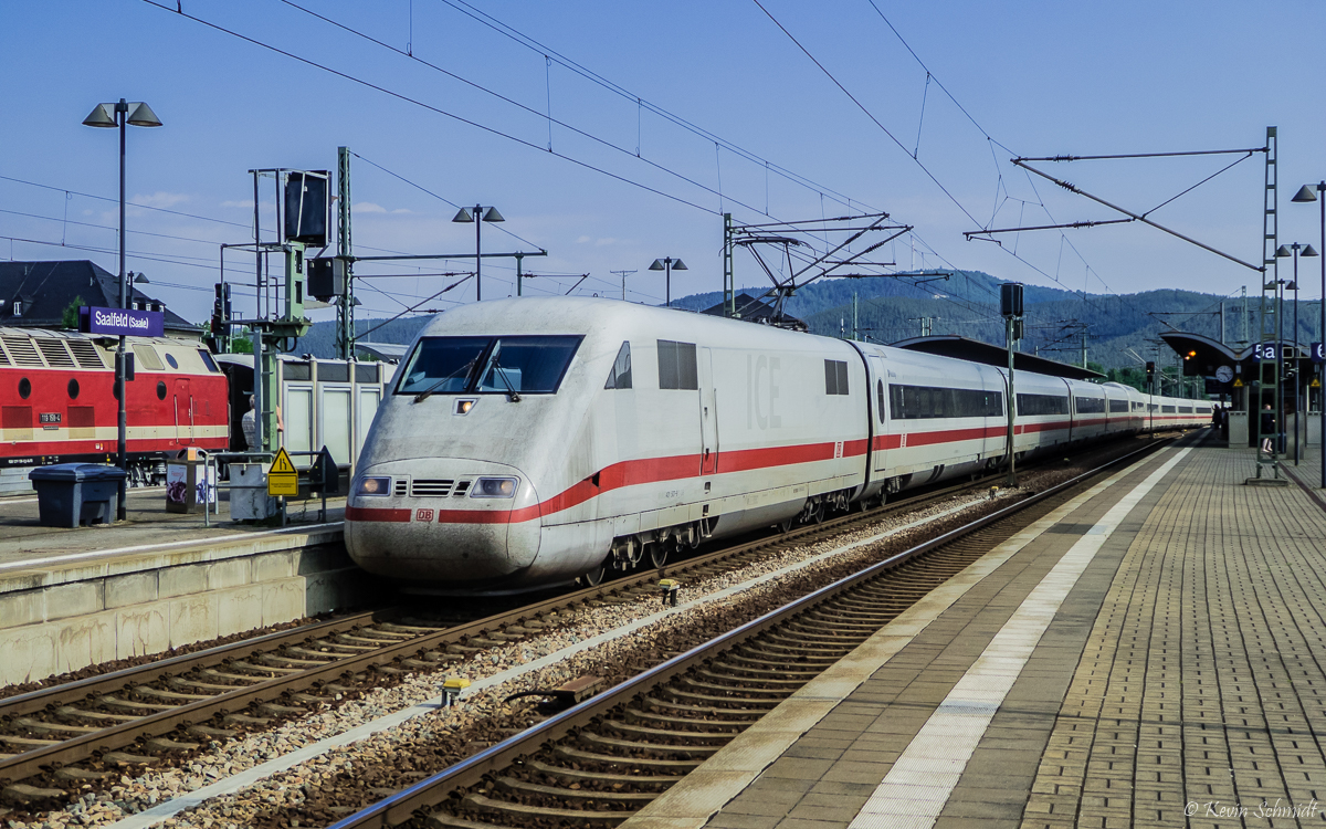 Ein ICE 1 erreicht als ICE 701 Berlin - München den Bahnhof Saalfeld(Saale) auf Gleis 4. Wegen einer gut eintägigen Sperrung des Bahnhofs Erfurt verkehrten an jenem Tag alle direkten ICE-Linien Berlin - München noch einmal über die Altstrecke durch Saaletal und Frankenwald. Auch weiter westlich auf Gleis 2 ist ein begehrtes Fotomotiv zu sehen. (22.06.2019)