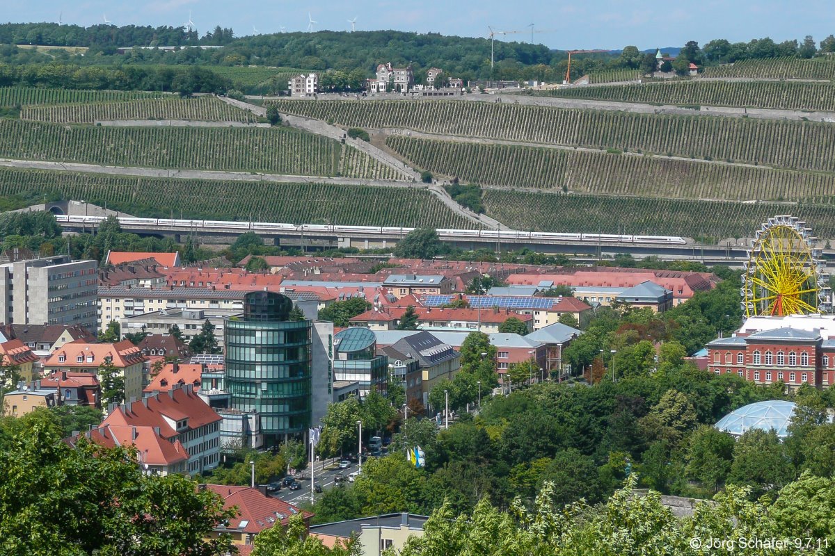 Ein ICE-2-Pärchen verließ am 9.7.11 den Steinbergtunnel und rollte auf den Würzburger Hbf (rechts vom Bildrand) zu. Das Riesenrad grüßte vom Kiliani-Volksfest, dem größten Volksfest Mainfrankens.