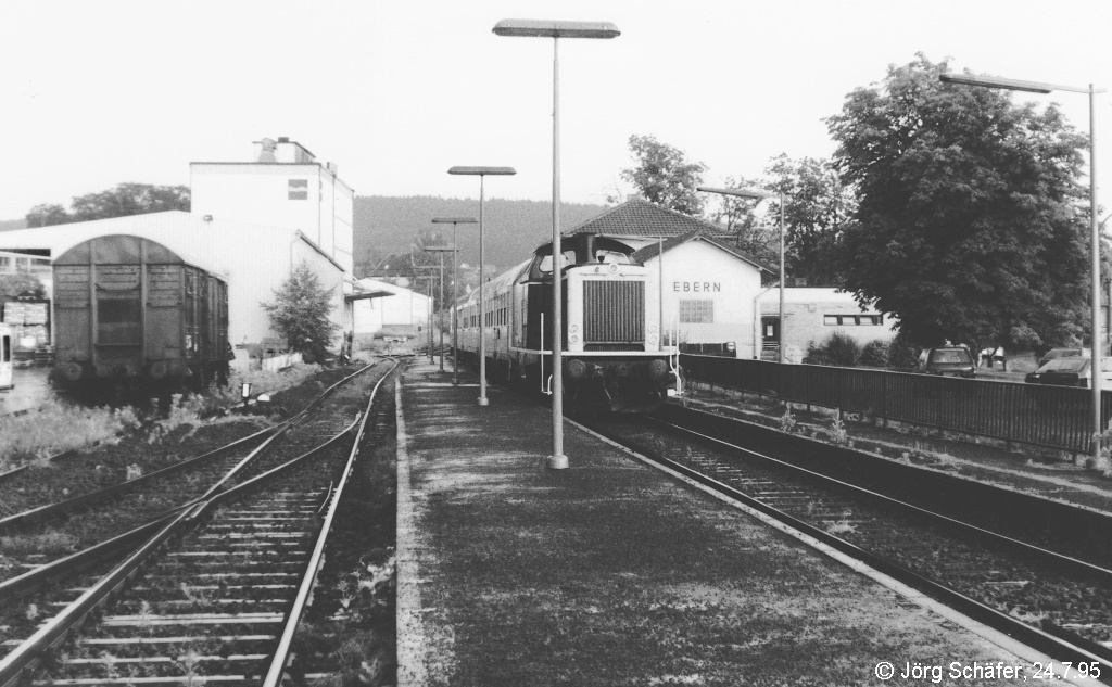 Ein Jahr nach dem Bild ID 840404 fuhren wieder Steuerwagenzüge auf der KBS 826, Zuglok am 24.7.95 war die 212 103. Kaum zu glauben, dass heute im Bahnhof Ebern nicht nur alle Gleise, sondern auch das Lagerhaus am linken Bildrand und das Empfangsgebäude hinter der Lok verschwunden sind.