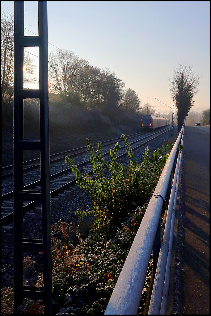 Ein kalter Morgen mit Sonnenschein -

Die Minusgrade führten zu Raureif, was die Kanten des Oberleitungsmasten weiß erscheinen lässt, ebenso wie dieser weiße 'Belag' auf dem Holzgeländer rechts. 

Ein S-Bahnzug zwischen Rommelshausen und Waiblingen auf der Remsbahn.

25.11.2020 (M)