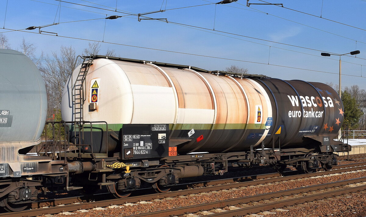 Ein Kesselwagen vom Einsteller WASCOSA in etwas anderer Farbgestaltung mit der Nr. 33 RIV 80 D-WASCO 7844 822-6 Zans Ladegut lt. UN-Nr: 33/1203 = Benzin in einem Ganzzug  am 07.02.23 Durchfahrt Bahnhof Flughafen BER Terminal 5