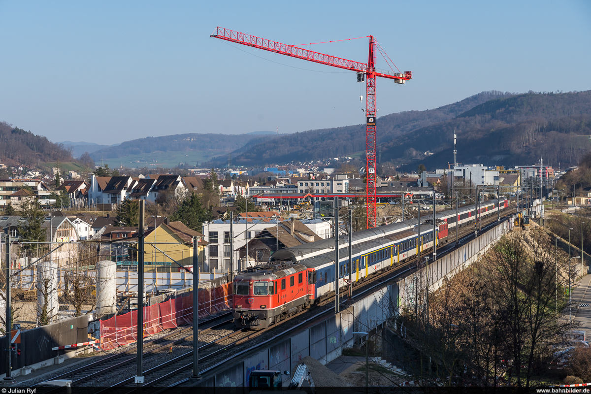 Ein kurzer EW-I-Pendel als IC Zürich HB - Basel SBB begegnet am 28. Februar 2021 vor Liestal seinem deutlich längeren Gegenzug. Wahrscheinlich aufgrund eines Defekts am Steuerwagen verkehrt der Pendelzug deutlich übermotorisiert mit zwei Loks. Auch an dieser Stelle sind die Baumassnahmen für den Vierspurausbau sichtbar.