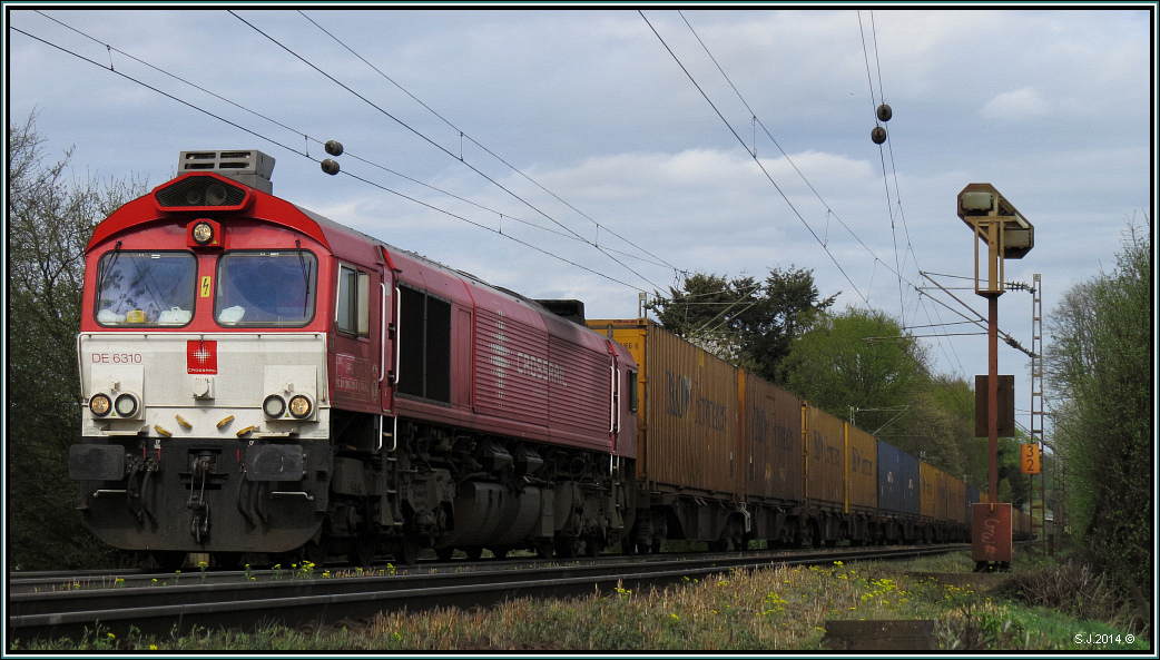 Ein langer Containerzug, mit der Crossrail Class 66 als Zugpferd,fährt die Gemmmenicher Rampe hinauf nach Belgien. Szenario vom 6.April 2014 unweit von Aachen. 
